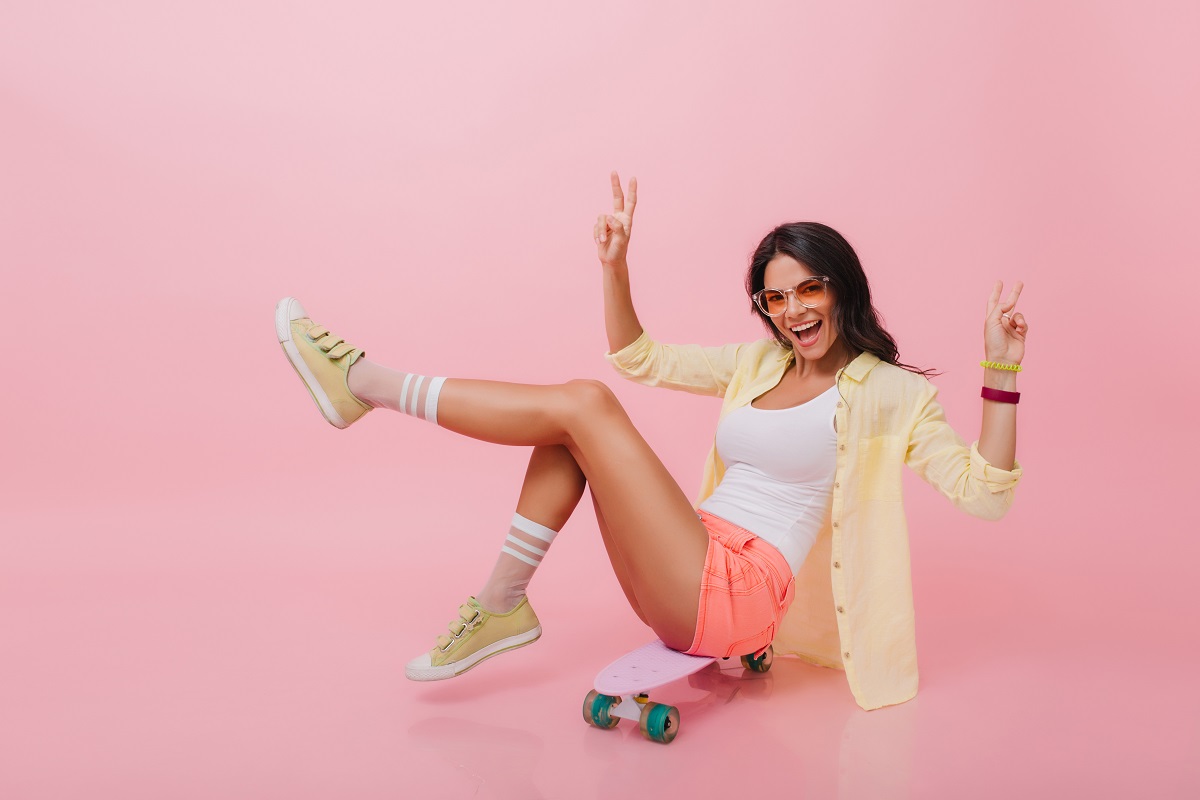 Linda mulher com pele bronzeada de shorts com seu tênis confortável